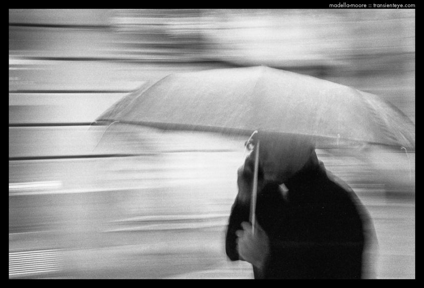 Motion-Blurred Image of a  Priest in the Rain under an umbrella